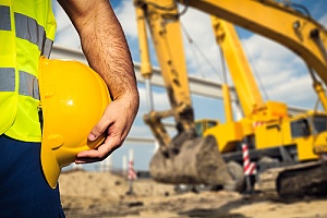 Worker holding helmet on construction site