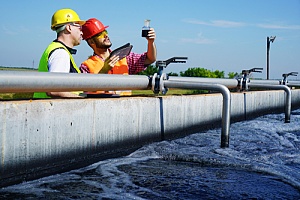 Workers at water treatment plant checking water levels for specification consulting