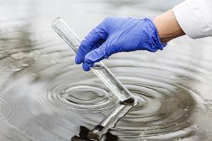 A technician collecting water sample on a test tube. Bag filtration is one of the water filtration solutions