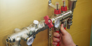 plumber checks the temperature of the pipes after applying glycol to the piping system
