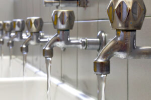 water pouring out of faucet are collected to be tested for legionella