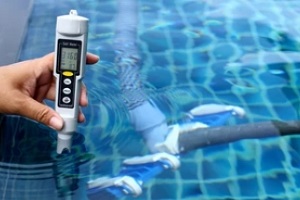 man measuring water ph in pool