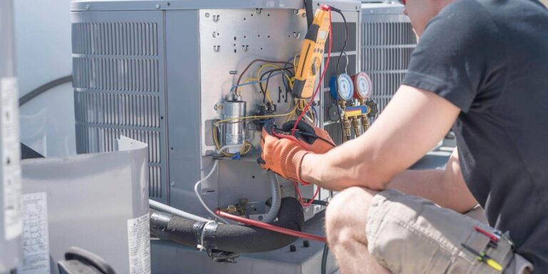 hvac technician working on controls of air conditioner