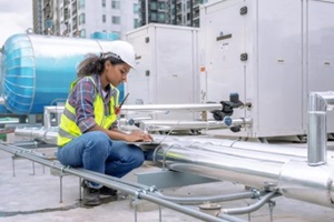 female engineer inspects and controls the cooling system of a large factory air conditioner