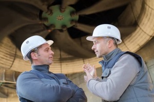 engineers talking under an industrial cooling fan