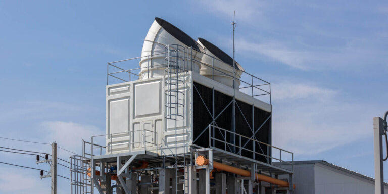 air conditioning cooling towers in front of building with fins to the front