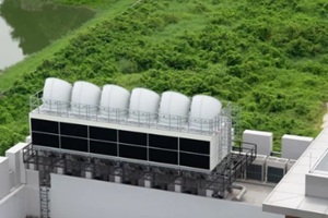 tower cooling on building roof against green grass background